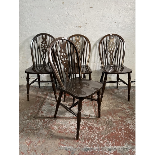 142 - Four beech wheelback dining chairs