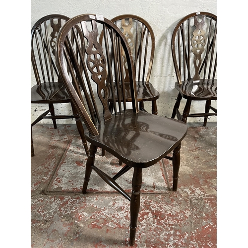 142 - Four beech wheelback dining chairs