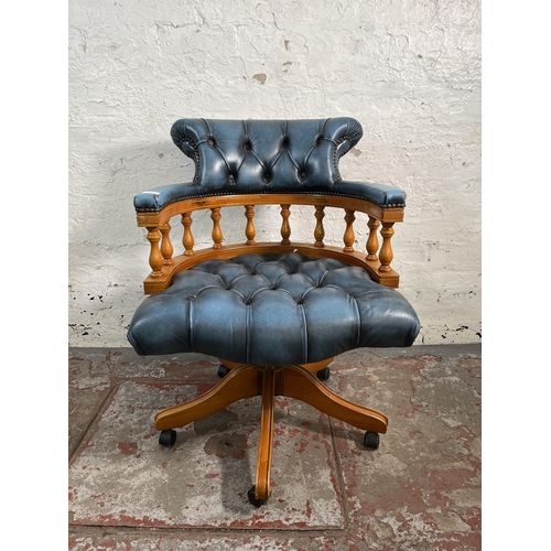 143 - A yew wood and blue leather Chesterfield captain's swivel desk chair