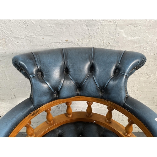 143 - A yew wood and blue leather Chesterfield captain's swivel desk chair