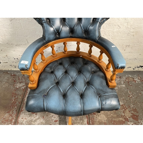 143 - A yew wood and blue leather Chesterfield captain's swivel desk chair