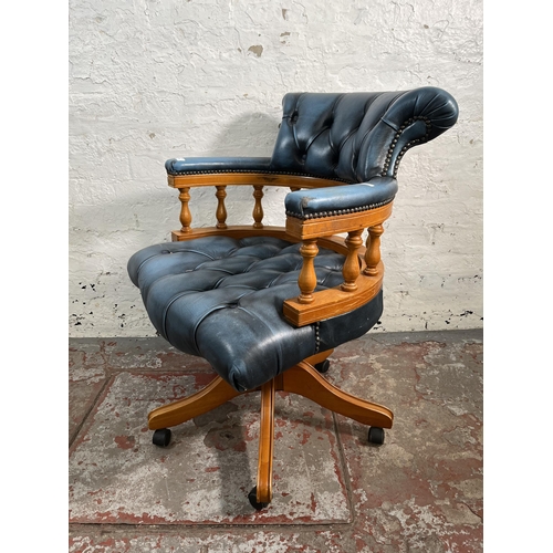 143 - A yew wood and blue leather Chesterfield captain's swivel desk chair
