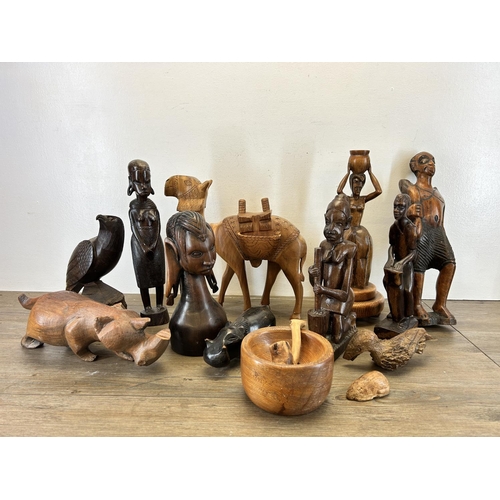 501 - A collection of treenware to include carved eagle, tribal style figurines, carved rhino etc.
