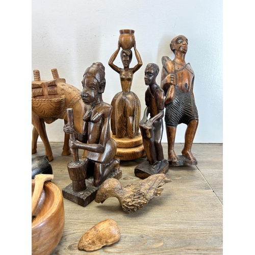 501 - A collection of treenware to include carved eagle, tribal style figurines, carved rhino etc.