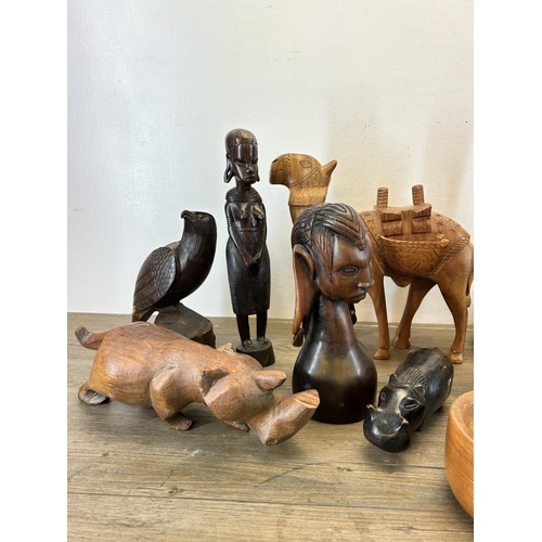 501 - A collection of treenware to include carved eagle, tribal style figurines, carved rhino etc.