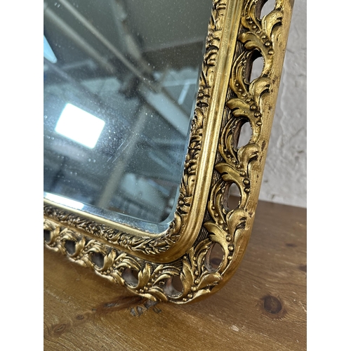 203 - Two gilt framed bevelled edge wall mirrors - largest approx. 103cm high x 71cm wide