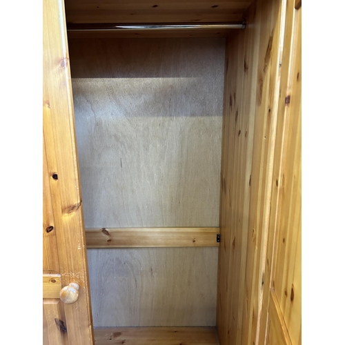 1 - A pine three piece bedroom suite comprising double wardrobe, bedside chest of drawers and dressing t... 