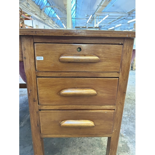 15 - A 1950s stained oak and red leather office desk - approx. 70cm high x 122cm wide x 68cm deep