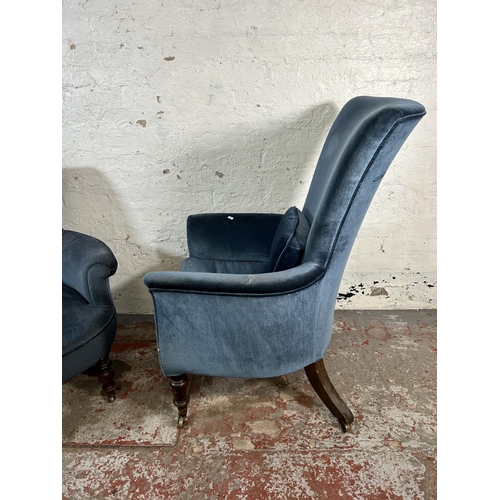18 - Two Victorian blue fabric upholstered armchairs with turned wooden supports and castors