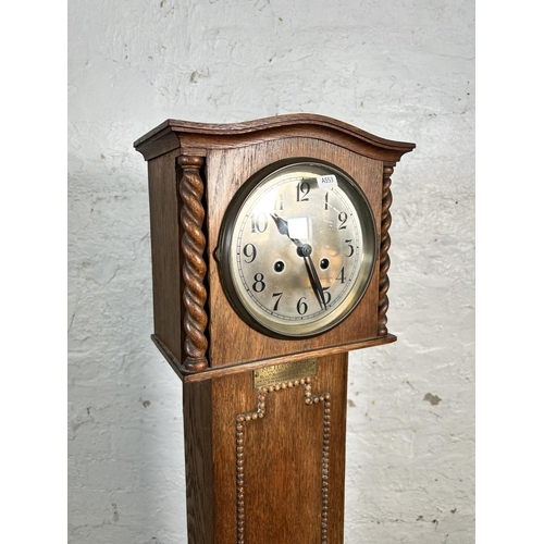 33 - A 1920s oak cased chiming Granddaughter clock with beaded decoration and barley twist supports - app... 