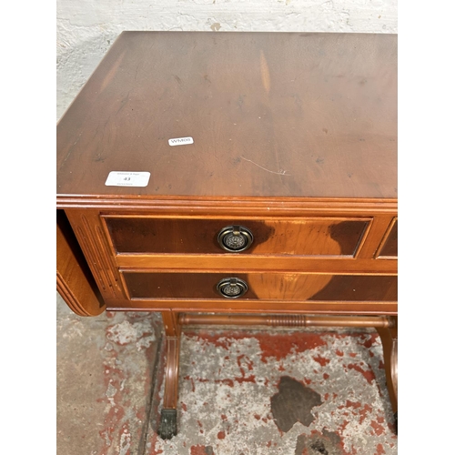 43 - A Regency style yew wood drop leaf three drawer sofa table with brass lion paw feet and lower stretc... 