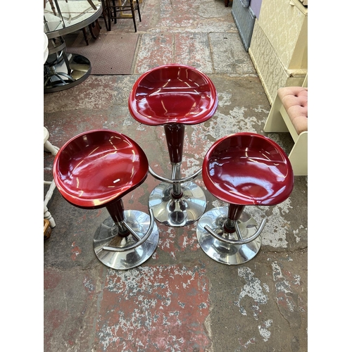 69 - Three red plastic and chrome plated kitchen bar stools - approx. 86cm high