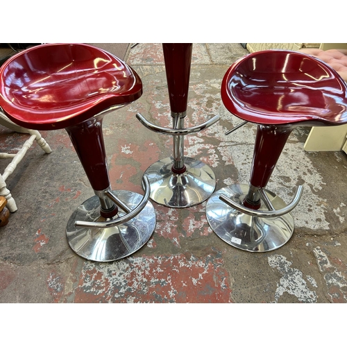 69 - Three red plastic and chrome plated kitchen bar stools - approx. 86cm high