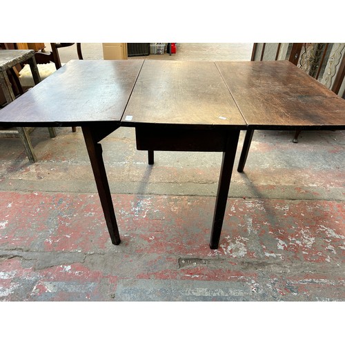 61 - A George III mahogany drop leaf dining table - approx. 71cm high x 91cm wide x 135cm long