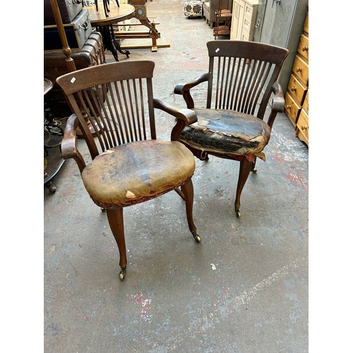 56 - A pair of Edwardian oak desk chairs - approx. 92cm high x 63cm wide x 50cm deep