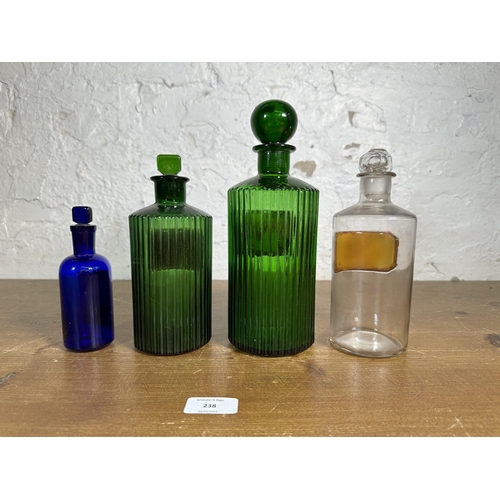 238 - Four early 20th century glass apothecary bottles - largest approx. 25cm high