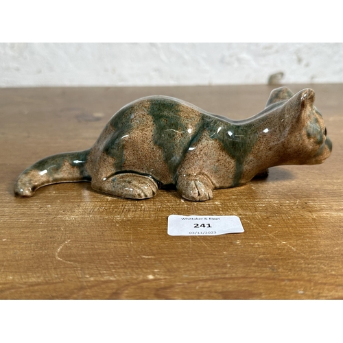 241 - A Brannam Barnstaple pottery mottled glazed cat figurine, signed to base - approx. 21cm long