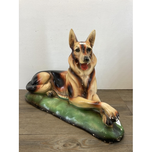 286 - Two 1930s plaster German Shepherd dog figurines - largest approx. 40cm high x 58cm long x 21cm wide