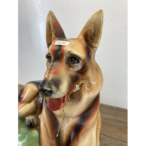 286 - Two 1930s plaster German Shepherd dog figurines - largest approx. 40cm high x 58cm long x 21cm wide