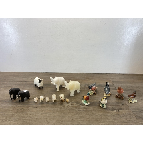 326 - A collection of animal figurines to include seven Beswick, two carved hardwood elephants etc.