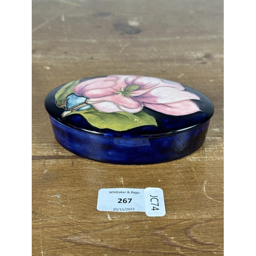 267 - Three pieces of Moorcroft pottery, two Magnolia pattern trinket boxes and one heart shaped trinket b... 