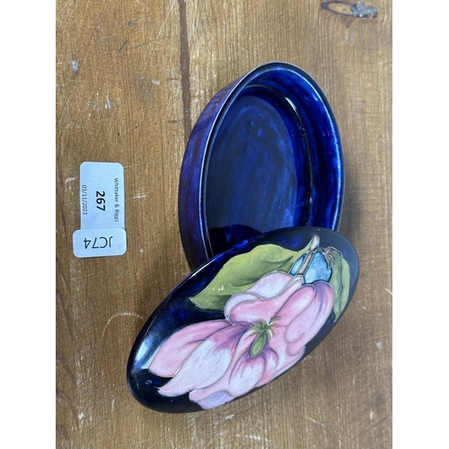 267 - Three pieces of Moorcroft pottery, two Magnolia pattern trinket boxes and one heart shaped trinket b... 