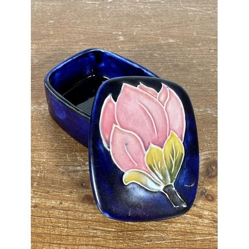 267 - Three pieces of Moorcroft pottery, two Magnolia pattern trinket boxes and one heart shaped trinket b... 