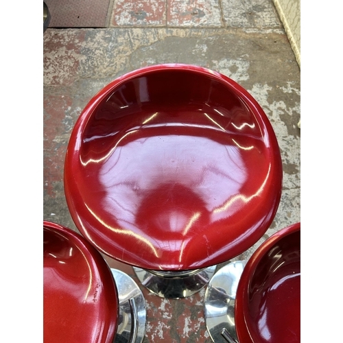 69 - Three red plastic and chrome plated kitchen bar stools - approx. 86cm high