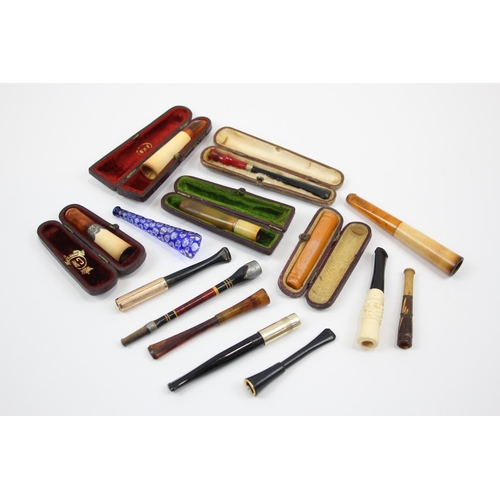 2340 - A collection of cheroot holders to include meerschaum, amber glass etc.