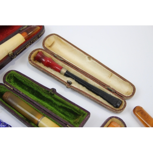 2340 - A collection of cheroot holders to include meerschaum, amber glass etc.