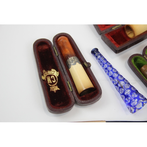 2340 - A collection of cheroot holders to include meerschaum, amber glass etc.