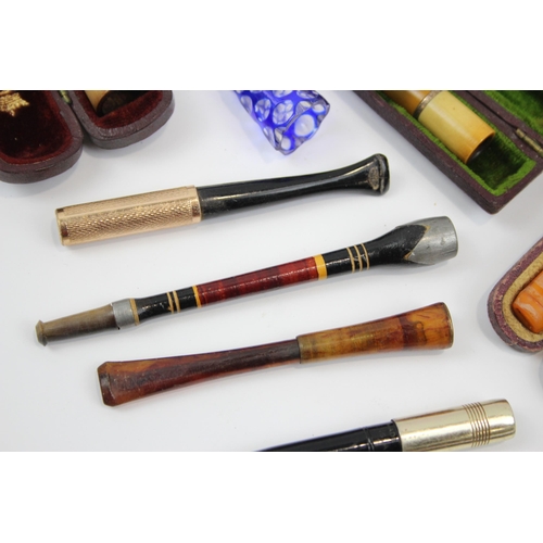 2340 - A collection of cheroot holders to include meerschaum, amber glass etc.