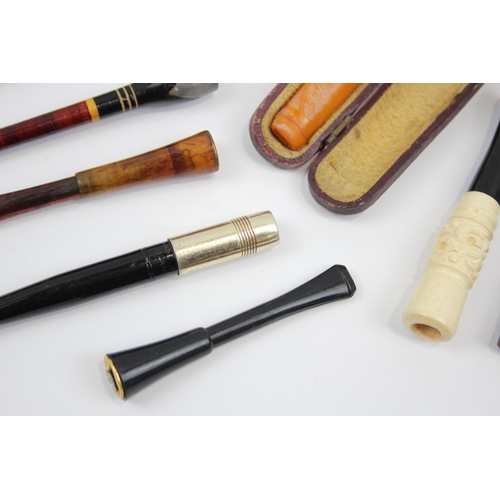 2340 - A collection of cheroot holders to include meerschaum, amber glass etc.