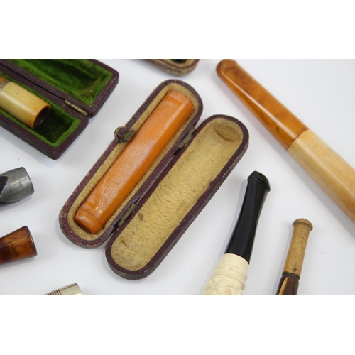 2340 - A collection of cheroot holders to include meerschaum, amber glass etc.