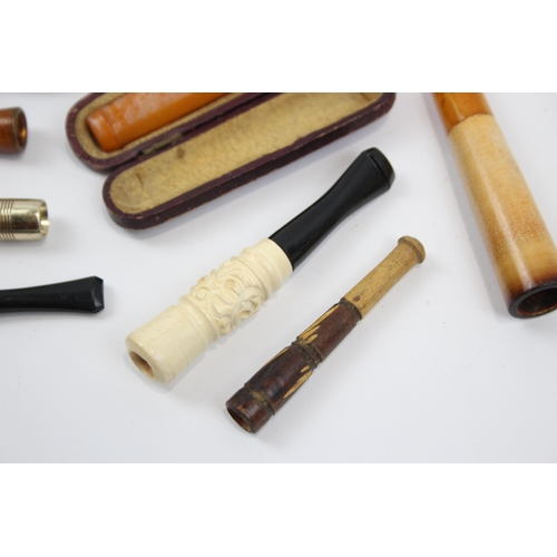 2340 - A collection of cheroot holders to include meerschaum, amber glass etc.