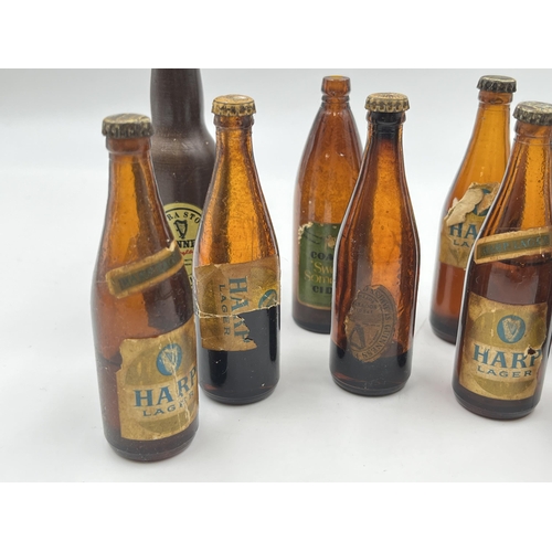 2360 - A collection of vintage miniature glass beer bottles together with Guinness bottle opener