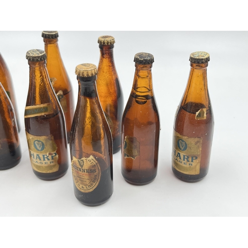 2360 - A collection of vintage miniature glass beer bottles together with Guinness bottle opener