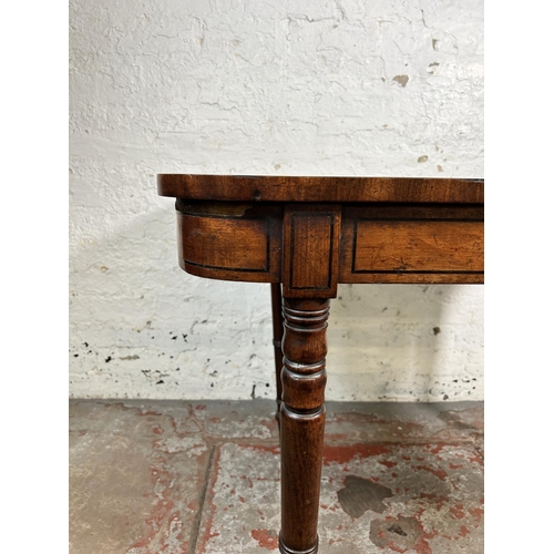 34 - A 19th century ebony inlaid mahogany fold over games table with green baize interior - approx. 74cm ... 