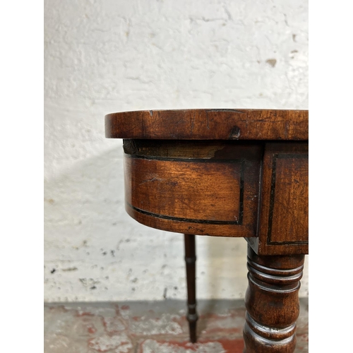 34 - A 19th century ebony inlaid mahogany fold over games table with green baize interior - approx. 74cm ... 