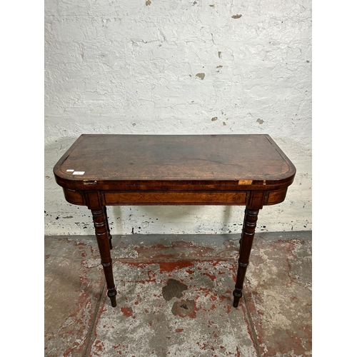 34 - A 19th century ebony inlaid mahogany fold over games table with green baize interior - approx. 74cm ... 