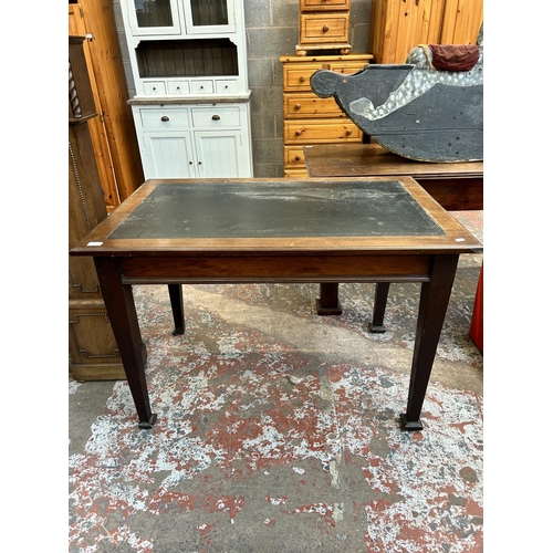 35 - An Arts & Crafts mahogany and black leather writing table - approx. 76cm high x 115cm wide x 76cm de... 