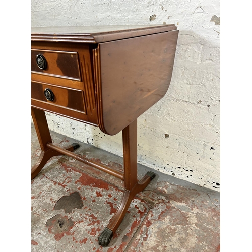 43 - A Regency style yew wood drop leaf three drawer sofa table with brass lion paw feet and lower stretc... 