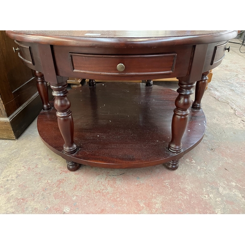 144 - A mahogany circular two tier coffee table - approx. 51cm high x 90cm diameter