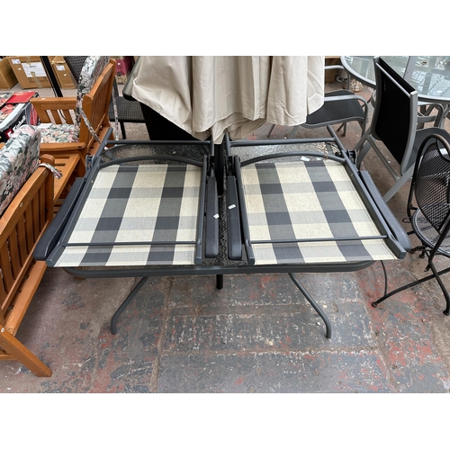 848 - A metal four piece patio dining set comprising glass top table, two chairs and parasol