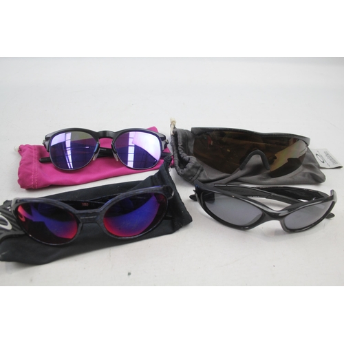 2179 - Four pairs of cased Oakley sunglasses