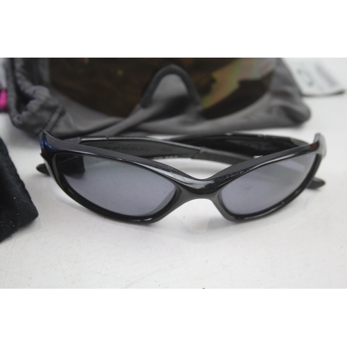 2179 - Four pairs of cased Oakley sunglasses