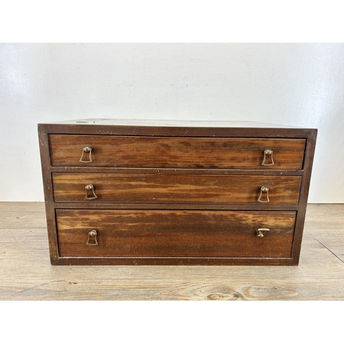 A vintage walnut three drawer cutlery canteen containing an assortment