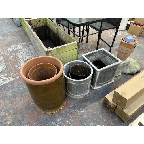 844 - A collection of garden items to include terracotta planters, cast stone bird bath base etc.