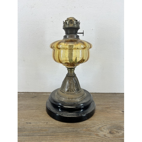 517 - A Victorian Falk's brass oil lamp with amber glass reservoir and ebonized base - approx. 31cm high