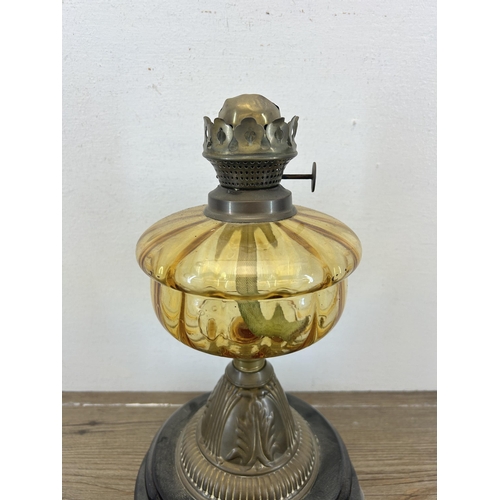 517 - A Victorian Falk's brass oil lamp with amber glass reservoir and ebonized base - approx. 31cm high